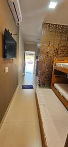 a room with two bunk beds and a flat screen tv at Loft proximo a orla 02 in Presidente Epitácio