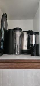 a shelf with three coffee pots and pans on it at Loft proximo a orla 02 in Presidente Epitácio