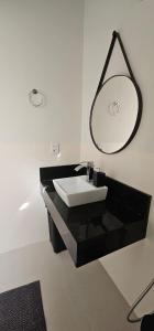 a bathroom with a black sink and a mirror at Loft proximo a orla 02 in Presidente Epitácio +12 photos