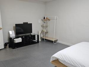 a bedroom with a bed and a flat screen tv at Taebaek The Palace Hotel in Taebaek