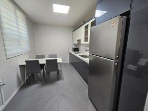 a kitchen with a refrigerator and a table with chairs at Taebaek The Palace Hotel in Taebaek +14 photos