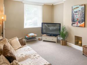 a living room with a couch and a television at The Bolt Hole in Wooler