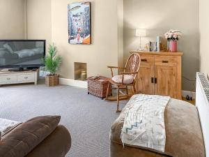 a living room with a bed and a tv at The Bolt Hole in Wooler