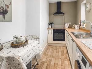 a kitchen with a table and a sink at The Bolt Hole in Wooler