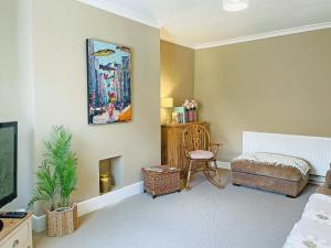a bedroom with a bed and a chair and a painting at The Bolt Hole in Wooler