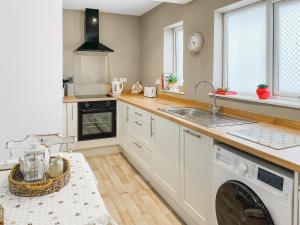 a kitchen with a sink and a dishwasher at The Bolt Hole in Wooler +9 photos