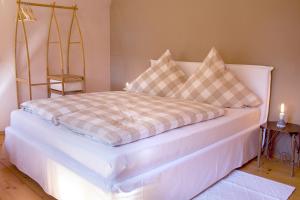 ein Bett mit einer karierten Decke und Kissen darauf in der Unterkunft Haus am Salinenweg in Grassau