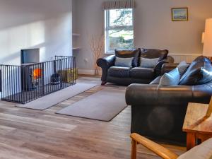 a living room with two couches and a fireplace at Clarksburn Blue in Monreith