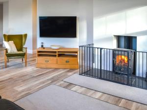a living room with a fireplace and a tv at Clarksburn Blue in Monreith