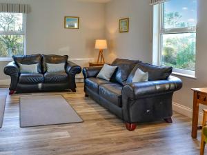 a living room with two leather chairs and a couch at Clarksburn Blue in Monreith +23 photos