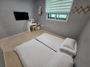 a small bedroom with a bed and a window at Taebaek The Palace Hotel in Taebaek