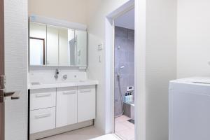 a white bathroom with a sink and a shower at -Numabukuro House- 10-minute walk from Numabukuro station in Tokyo
