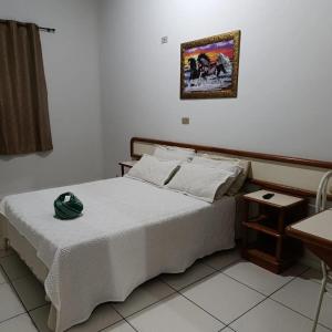 a bedroom with a bed and a picture on the wall at Hotel Internacional in Cianorte