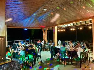 a group of people sitting at tables on a patio at Buxton Gan Resort Hotel in San Andres