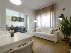 フィレンツェにあるGelsomino Apartmentのリビングルーム(白いソファ、テーブル付)