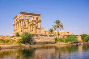 a building next to a body of water at Nubian Spirit in Aswân Reservoir Colony