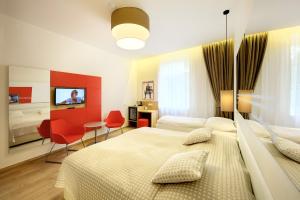 a bedroom with two beds and a table and chairs at Salvator Boutique Hotel vegan-friendly in Prague