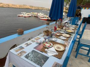 a table with food on it next to a body of water at Nubian Spirit in Aswân Reservoir Colony