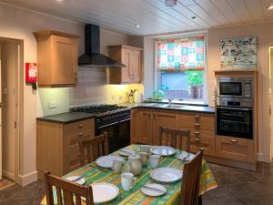 a kitchen with a table with plates on it at The Coyles - Uk31466 in Ballater