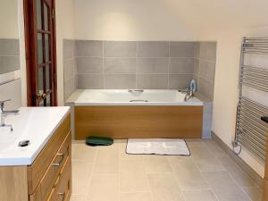 a bathroom with a tub and a sink at The Coyles - Uk31466 in Ballater +5 photos