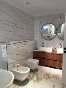 a bathroom with two sinks and a toilet and a mirror at Knight Rooms in Voluntari +40 photos