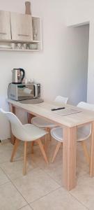 a kitchen with a table with chairs and a microwave at Atenea in Chivilcoy