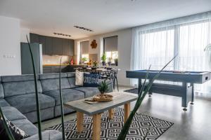 a living room with a couch and a pool table at Apartman Senec in Senec