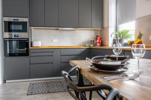 a kitchen with a wooden table with wine glasses at Apartman Senec in Senec