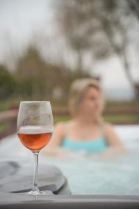 a woman in a bath tub with a glass of wine at Bibe Vendégház in Mónosbél +21 photos