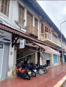 a group of motorcycles parked outside of a building at Bami hostel in Thakhek