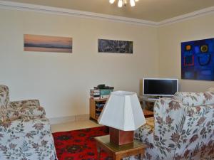 a living room with two chairs and a television at Waterside in Tighnabruaich
