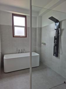 a bathroom with a bath tub and a phone at Sky Bloom Ahangama in Ahangama +22 photos