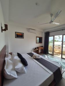 a bedroom with a large bed with pillows at Sky Bloom Ahangama in Ahangama