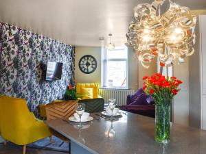 a dining room with a table with a vase of flowers at Hollingreave House in Burnley