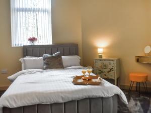 a bedroom with a bed with a tray of wine glasses at Hollingreave House in Burnley +12 photos