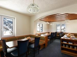 a dining room with tables and chairs and windows at Haus Vinzenz in Obertauern
