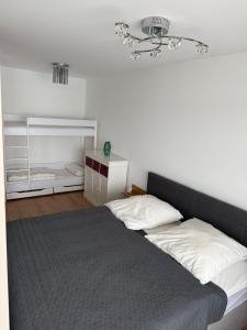 a bedroom with a bed with a gray blanket at FeWo am Hansa Park in Sierksdorf