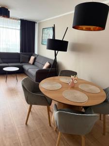 a living room with a table and a couch at FeWo am Hansa Park in Sierksdorf