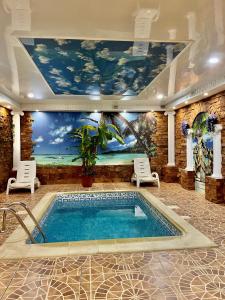 a swimming pool in a room with a painting on the wall at Flamingo in Aktobe