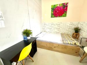 a room with a bed and a desk and a painting at LaMera Hotel Homestay in Ben Tre