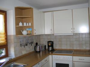 a kitchen with white cabinets and a sink at 2-Zimmer-Ferienwohnung Gartenblick in Rottweil