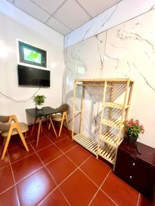 a living room with a table and a tv at LaMera Hotel Homestay in Ben Tre