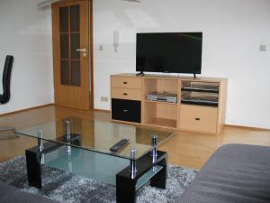 a living room with a tv and a glass coffee table at 2-Zimmer-Ferienwohnung Gartenblick in Rottweil