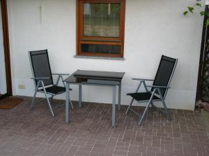 einen Tisch und zwei Stühle neben einer Wand in der Unterkunft 2-Zimmer-Ferienwohnung Gartenblick in Rottweil