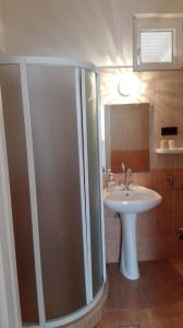 łazienka z prysznicem i umywalką w obiekcie Garden Apartmanház 2 w Hajduszoboszlo +7 zdjęć