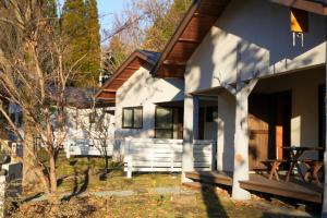 a white house with a picnic table in front of it at 阿蘇山麓のヴィラShijin南阿蘇 in Minami Aso