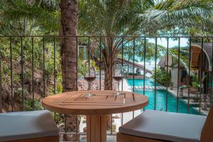 a table with wine glasses on a balcony with a pool at SeaTara Resort in Ko Phangan