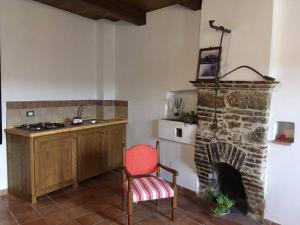 a kitchen with a red chair and a fireplace at A casa da Titta in San Martino dʼAgri