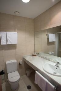 y baño con lavabo, aseo y bañera. en Hostal Mediterranea en Madrid