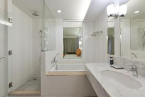 a white bathroom with two sinks and a shower at Hisea Huahin Hotel in Hua Hin